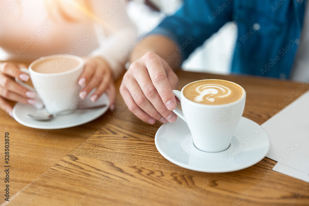 man and woman holding cups of hot coffee, closeup man and woman holding cups of hot coffee, closeup