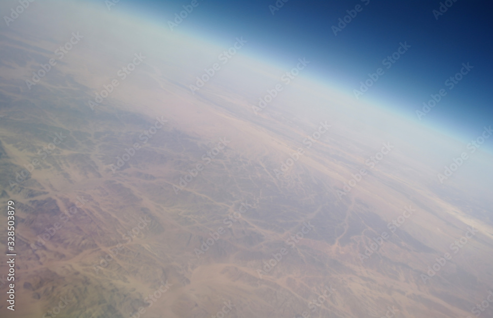 View from the plane window to the clouds and the earth