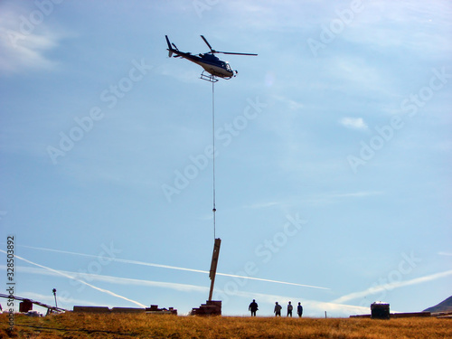 Helicopter transports a wood beam