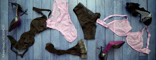 Top view at wooden blue painted floor with scattered underwear, stockings and shoes left by two lesbian women having date. Passionate homosexual relation high resolution banner concept.