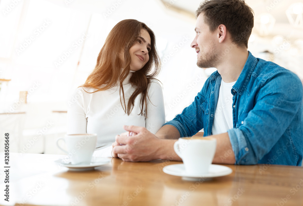young couple beautiful woman holding hands with her handsome man while drinking coffee in cafe during lunch time break, love and tenderness concept young couple beautiful woman holding hands with her handsome man while drinking coffee in cafe during lunch time break, love and tenderness concept