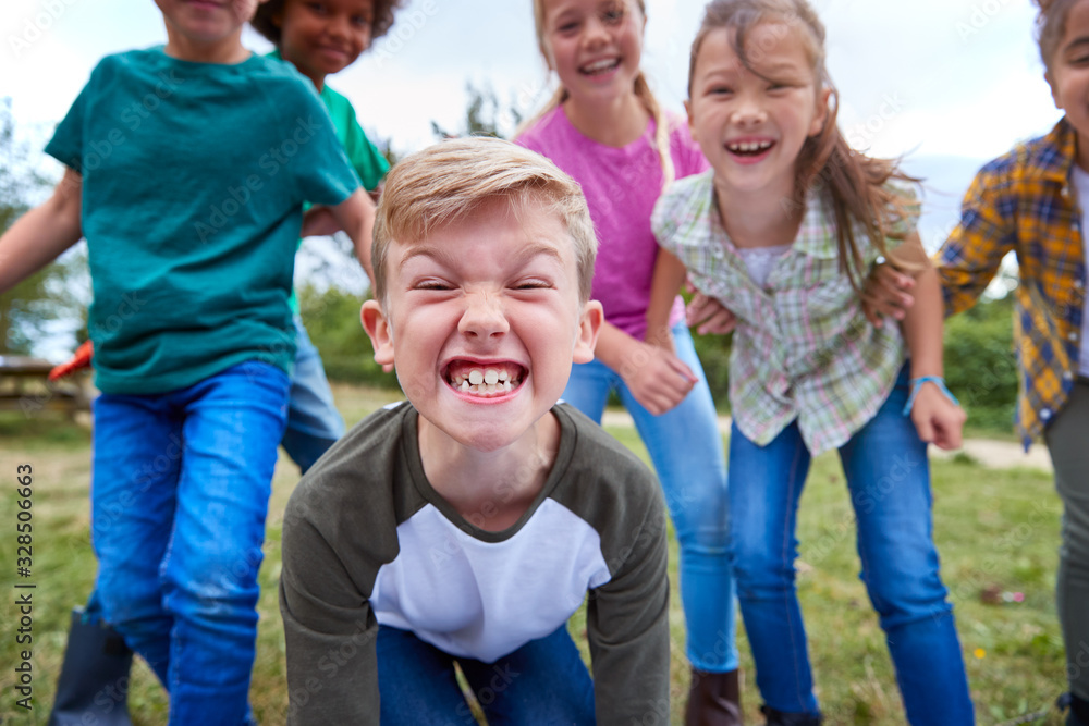 Portrait Of Children On Outdoor Activity Camping Trip Pulling Faces Having Fun Playing Game Together Portrait Of Children On Outdoor Activity Camping Trip Pulling Faces Having Fun Playing Game Together