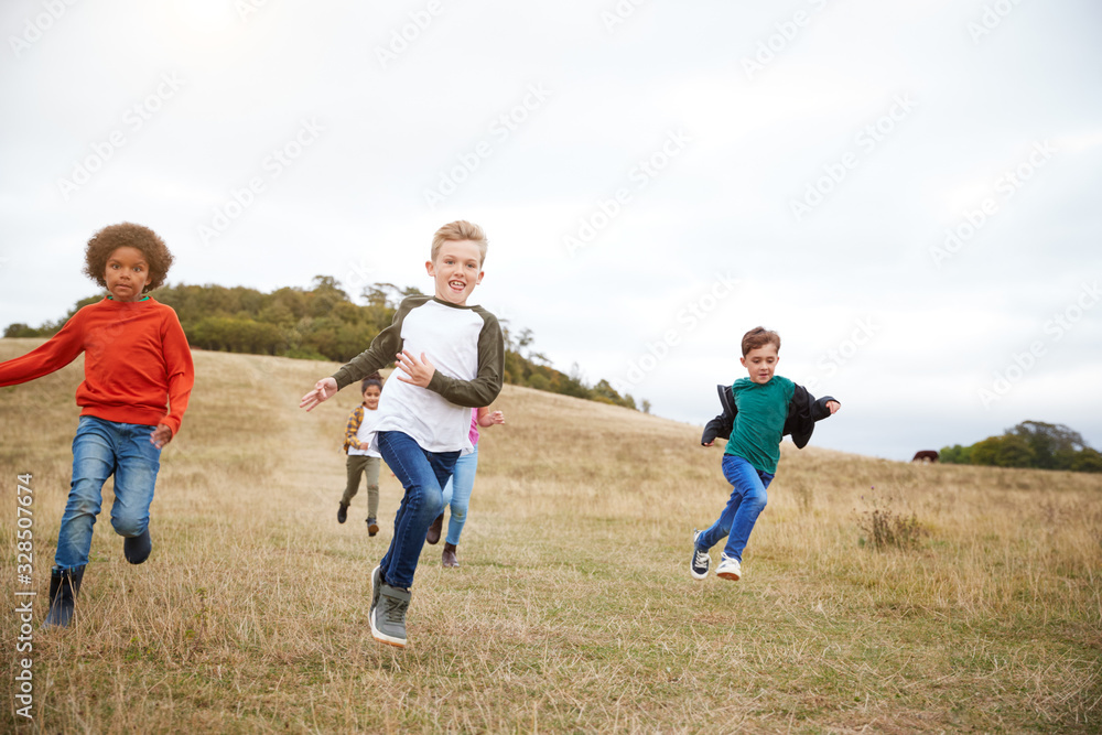 Front View Of Group Of Children On Outdoor Activity Camping Trip Running Down Hill Front View Of Group Of Children On Outdoor Activity Camping Trip Running Down Hill