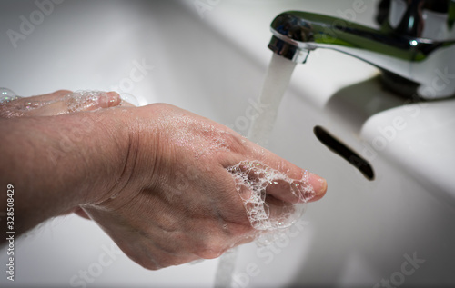 Woman hands in the sink soaped to avoid contagion