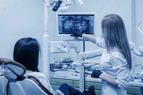 girl dentist shows on roentgen to patient