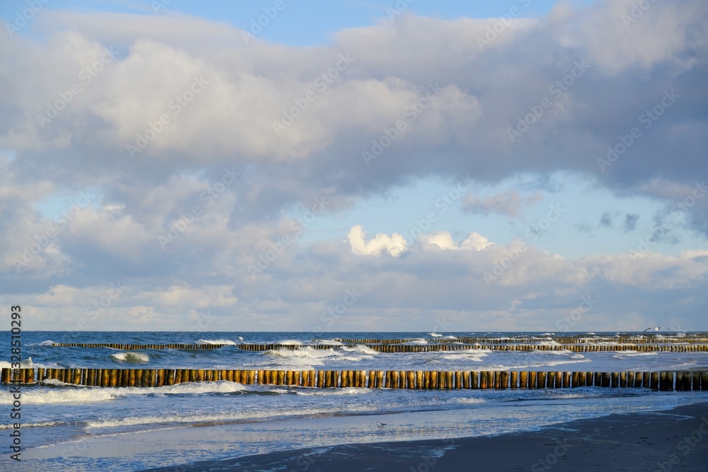 Waves crashing on the breakwater on a sunny day. Baltic Sea coast, Dziwnowek, Poland
