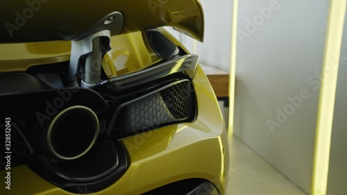 Modern yellow sport supercar exhaust system pipes close up photo