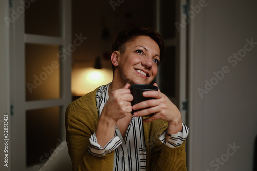 woman holding cup of coffee and daydreaming