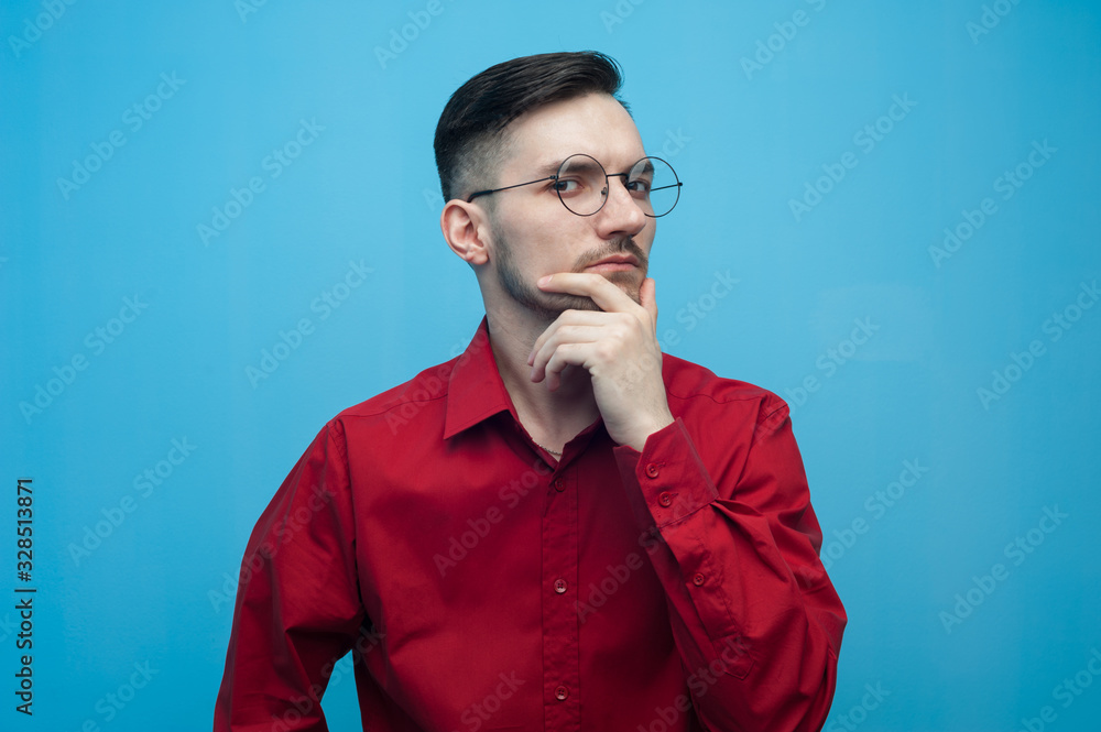 Pensive Young man in glasses and a burgundy shirt Pensive Young man in glasses and a burgundy shirt