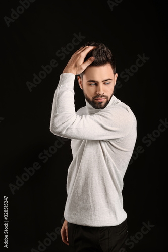 Handsome man with healthy hair on dark background © Pixel-Shot