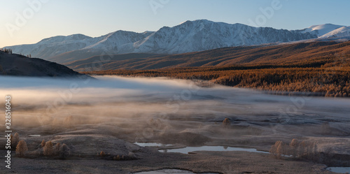 Autumn mountains at sunrise in the fog