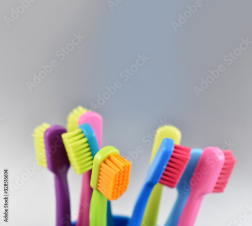 Different multi-colored toothbrushes stock images. Morning hygiene concept. Bathroom accessories images. Toothbrush on a silver background. Toothbrush on a light background with copy space for text