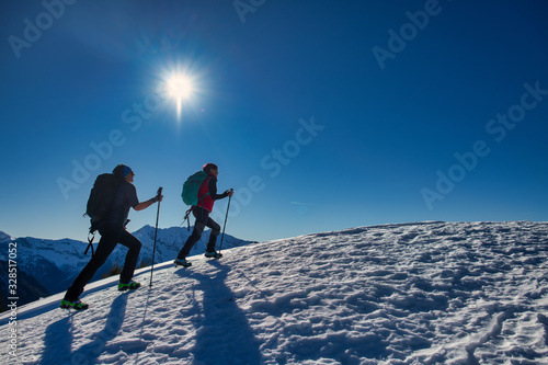 Tableau sur toile Couple of female friends during a snow hike in the mountains