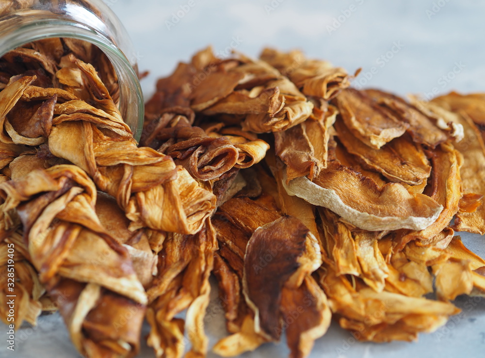 Dried melon chips in a glass jar on a wooden background. Home cooking. Natural healthy product, place for text.