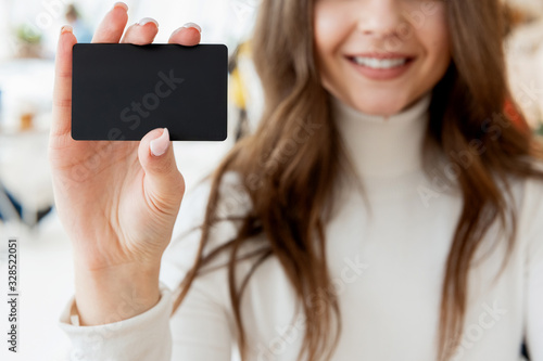 young brunette woman showing bank card looking satisfied, closeup, banking concept