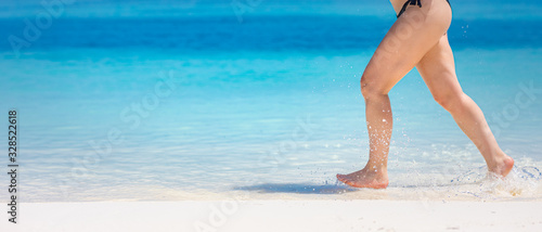 Happy beautiful woman running on the beach. Summer fun on beach vacation holiday