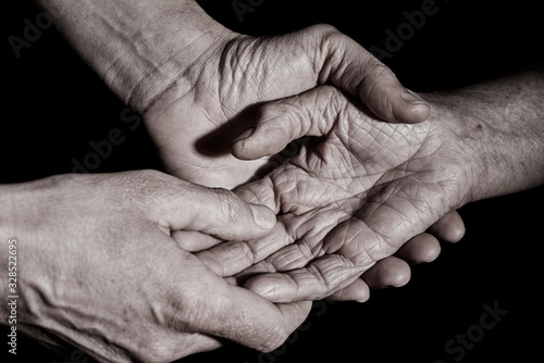 young man holding the hand of an old woman