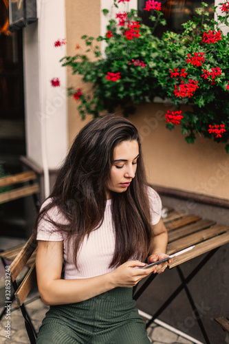 Beautiful woman using tablet sitting in street cafe.