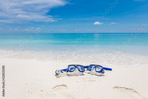 Summer sport, beach activity, beach recreational concept. Diving goggles and snorkel gear on white sand near beach. Summer vacation and recreational travel background photo