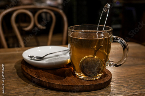glass cup with tea and tea leaves on a table in a loft cafe