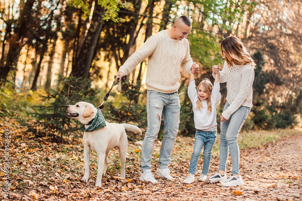Happy beautiful family with dog labrador is having fun together walking the in park. Happy beautiful family with dog labrador is having fun together walking the in park.