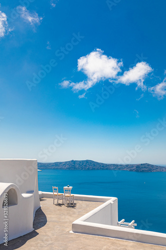 Couple honeymoon or romance background. Two chairs on the terrace with sea views. Santorini island  Greece. Romantic travel and vacation background