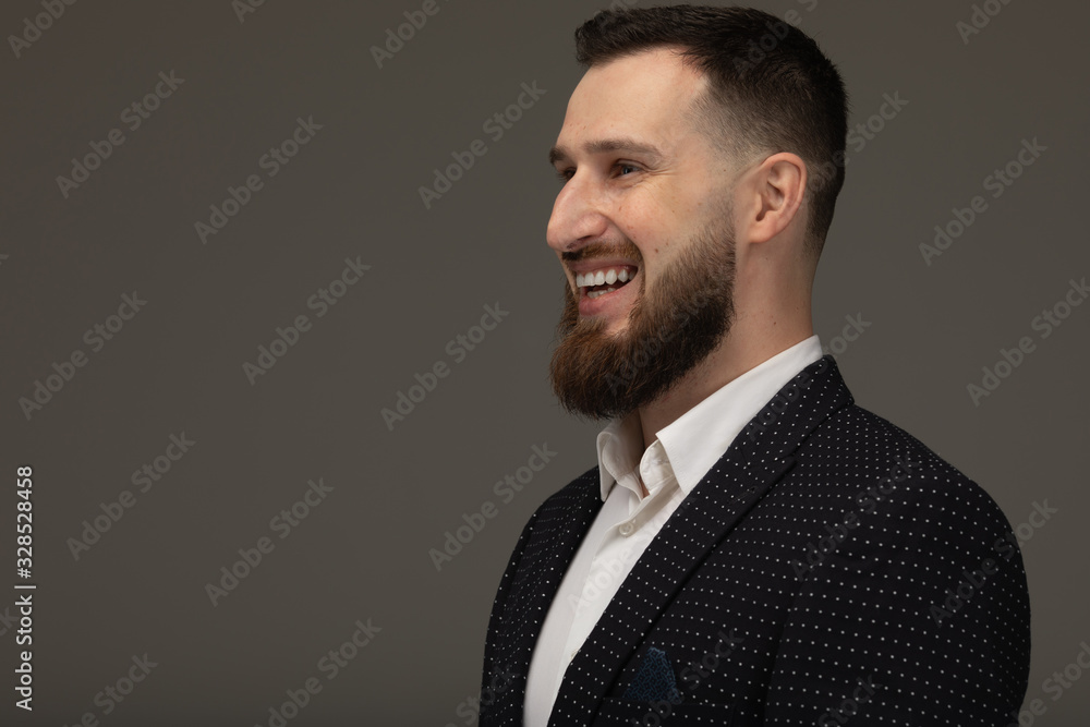 Portrait of a handsome bearded man smiling against grey background with copy space. Portrait of a handsome bearded man smiling against grey background with copy space.