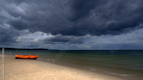 Fototapeta Naklejka Na Ścianę i Meble -  A lone boat before the storm. Empty coast of the Baltic sea.