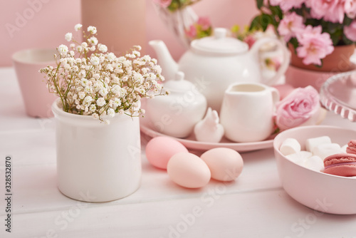 Easter table setting with cake,eggs and flowers. Happy Easter Greeting Card Template. Easter cake and colorful eggs on festive table. The concept of family celebration. Easter holiday.