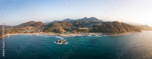 白い鳥居と夫婦岩 夕陽に輝く海岸線 全景 パノラマ 空撮