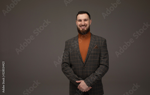 Handsome business man smiling at the camera on grey background.