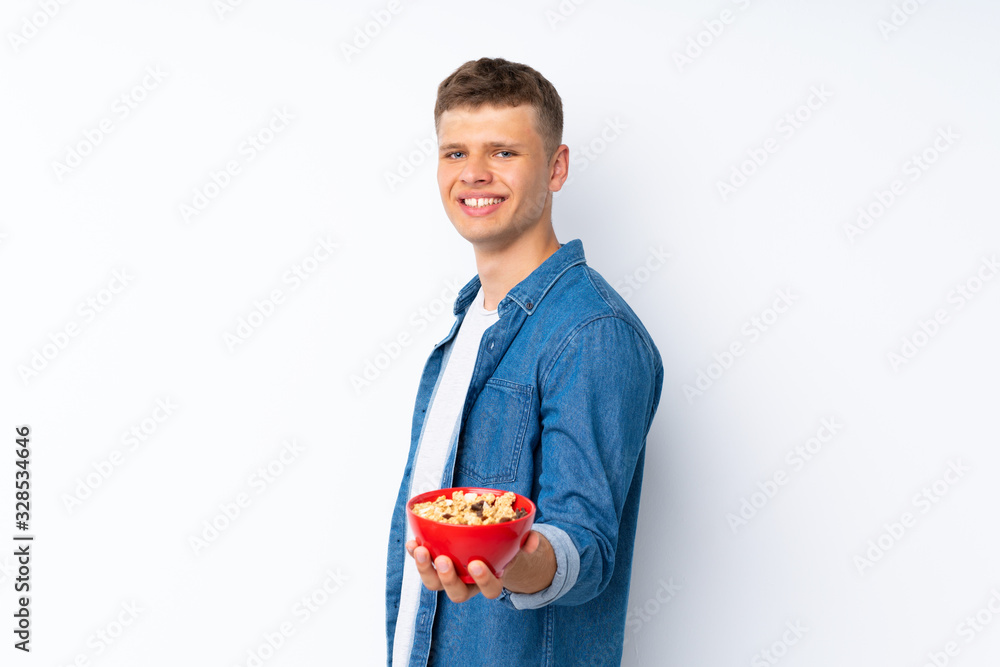Young handsome man over isolated white background holding a bowl of cereals