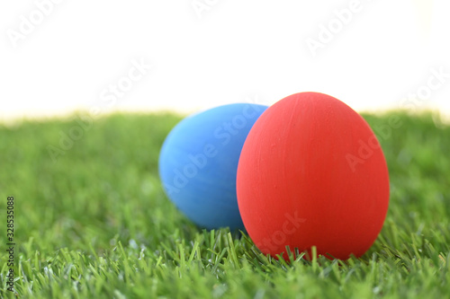 blue and red easter egg on lawn green grass artificial with blank white background