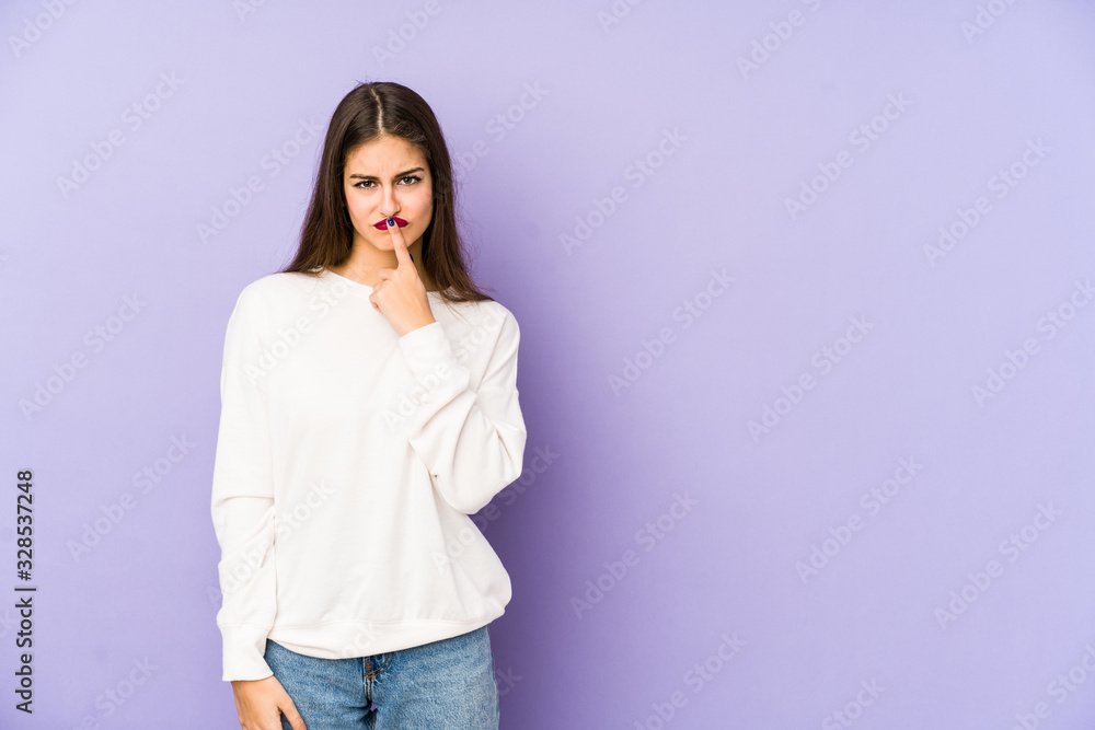 Young caucasian woman isolated on purple background thinking and looking up, being reflective, contemplating, having a fantasy. Young caucasian woman isolated on purple background thinking and looking up, being reflective, contemplating, having a fantasy.