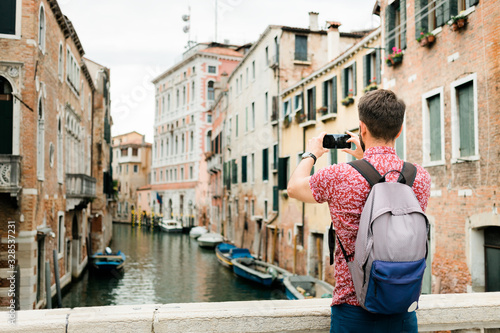 Young traveler taking a photo with his smartphone of a canal in Venice, Italy © marjan4782