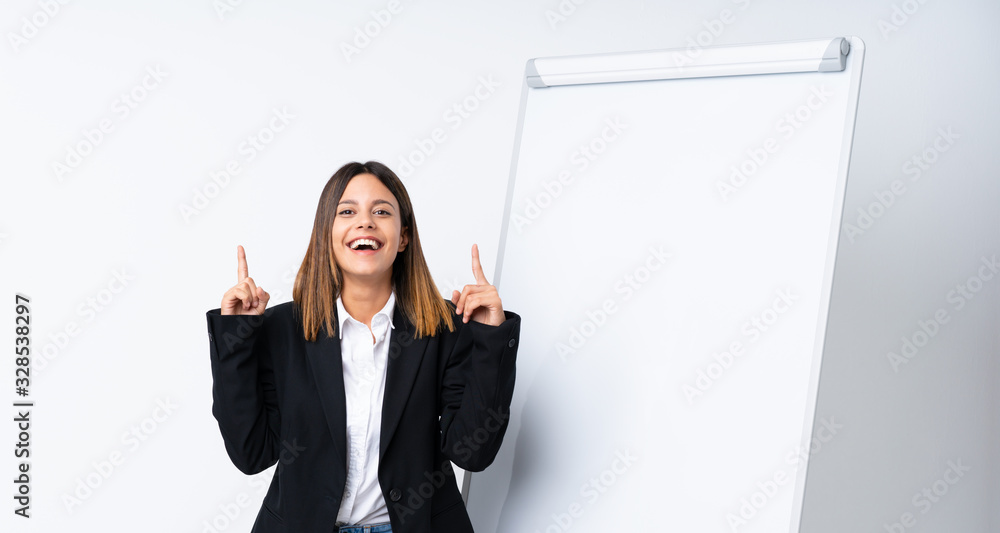 Young woman giving a presentation on white board pointing up a great idea Young woman giving a presentation on white board pointing up a great idea