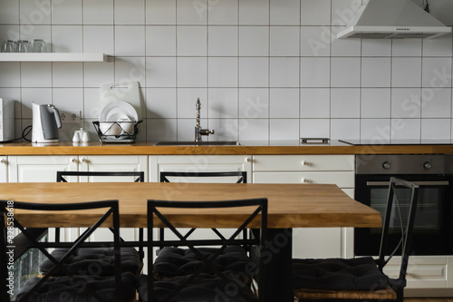 Modern, bright, clean, kitchen interior with stainless steel appliances in a luxury house. Kitchen in luxury mansion. Modern architecture contemporary, interior. Stylish kitchens interior with table.