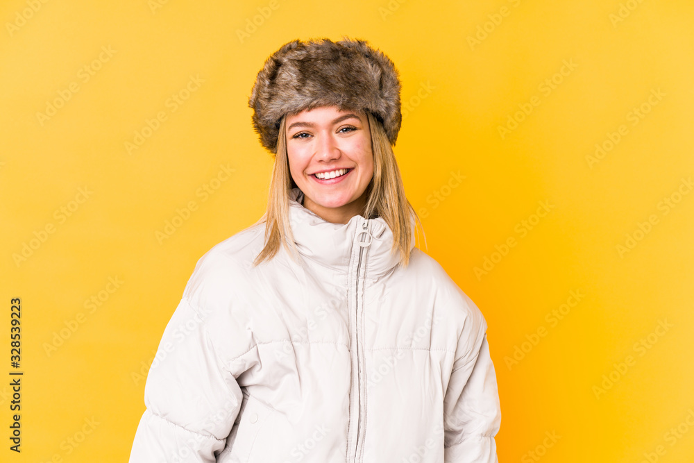 Young blonde woman wearing a winter clothes isolated Young blonde woman isolated on yellow background happy, smiling and cheerful.< mixto > Young blonde woman wearing a winter clothes isolated Young blonde woman isolated on yellow background happy, smiling and cheerful.< mixto >
