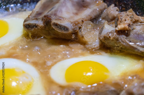 Fried eggs and pieces of meat in a frying pan in sunflower oil close-up. concept of homemade food