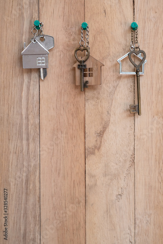 Heart shape house key with home keyring on wood fence background
