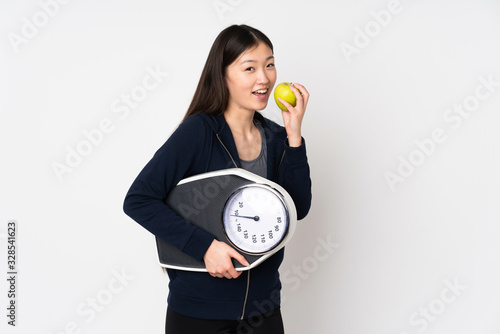 Cuadro en lienzo Young asian woman isolated on white background with weighing machine and with an