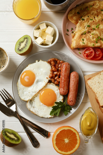 Delicious breakfast or lunch with fried eggs on white wooden background, top view