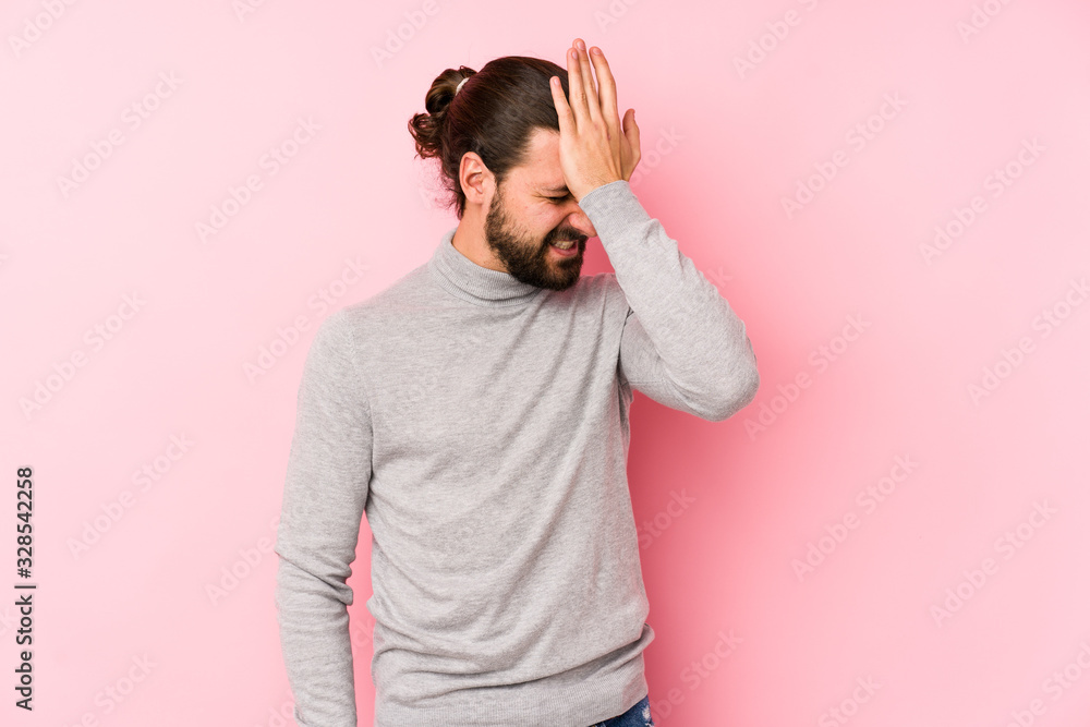 Young long hair man isolated on a pink background forgetting something, slapping forehead with palm and closing eyes. Young long hair man isolated on a pink background forgetting something, slapping forehead with palm and closing eyes.
