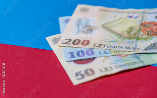Romanian banknotes on a blue and red background. Coloseup of RON, Romanian Currency. Romanian RON, Lei Banknotes issued by BNR, National Bank of Romania. Romania Finance and economy concept