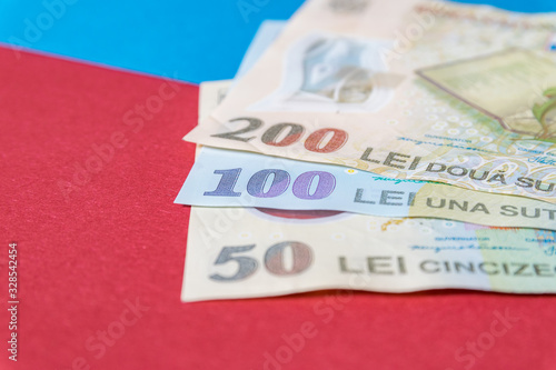 Obraz na płótnie Romanian banknotes on a blue and red background. Coloseup of RON, Romanian Currency. Romanian RON, Lei Banknotes issued by BNR, National Bank of Romania. Romania Finance and economy concept w salonie