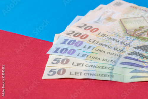 Romanian banknotes on a blue and red background. Coloseup of RON, Romanian Currency. Romanian RON, Lei Banknotes issued by BNR, National Bank of Romania. Romania Finance and economy concept