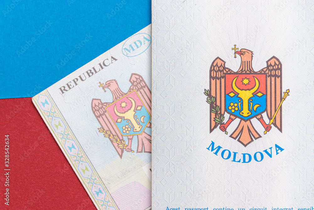 Republic of Moldova concept. The Moldovan passport on a blue and red background. Coloseup of the emblem/coat of arms of Moldova. Moldova Finance and economy concept