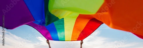 Foto Gay Rainbow Flag on a green meadow outdoors