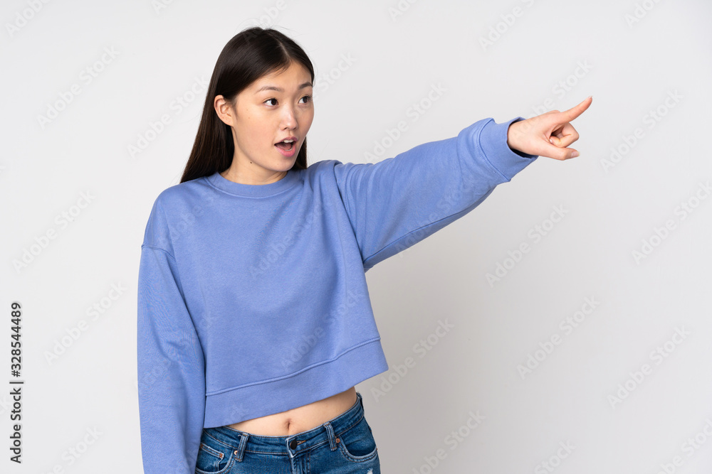 Young asian woman isolated on background pointing away Young asian woman isolated on background pointing away
