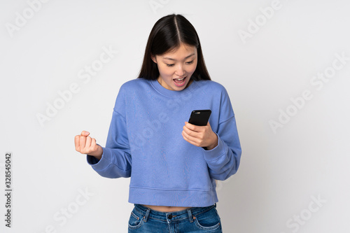 Young asian woman isolated on background surprised and sending a message